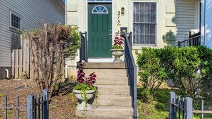 A two-story house with a green door, a number '375' above the door, and a small porch with a railing. - Only 8 min to Ohio State University! (Columbus)