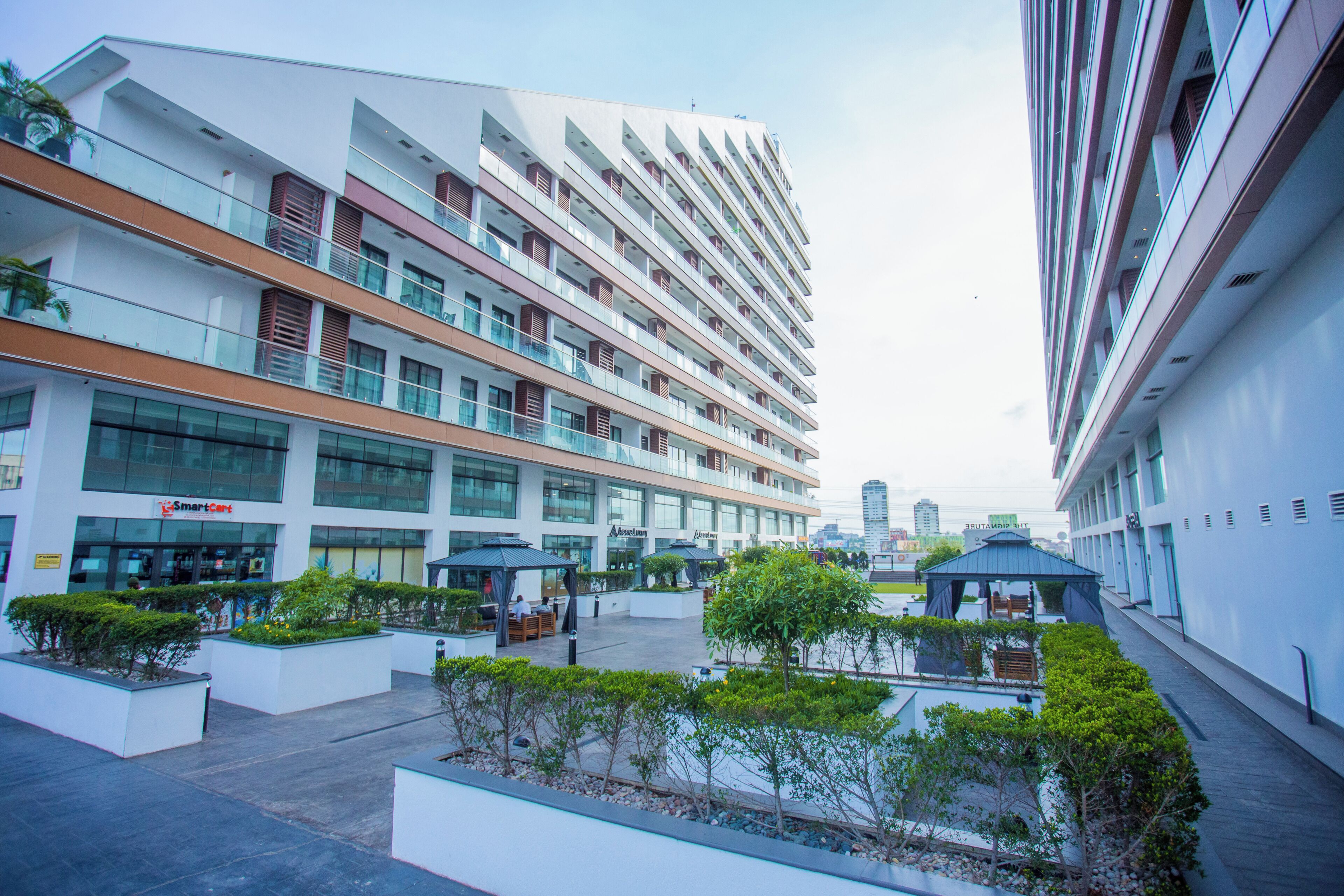 A multi-story hotel with outdoor seating areas and a view of the city skyline.