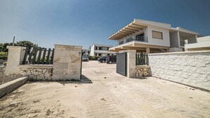 Un immeuble résidentiel moderne doté d’une allée pavée et d’une entrée sécurisée par un portail.