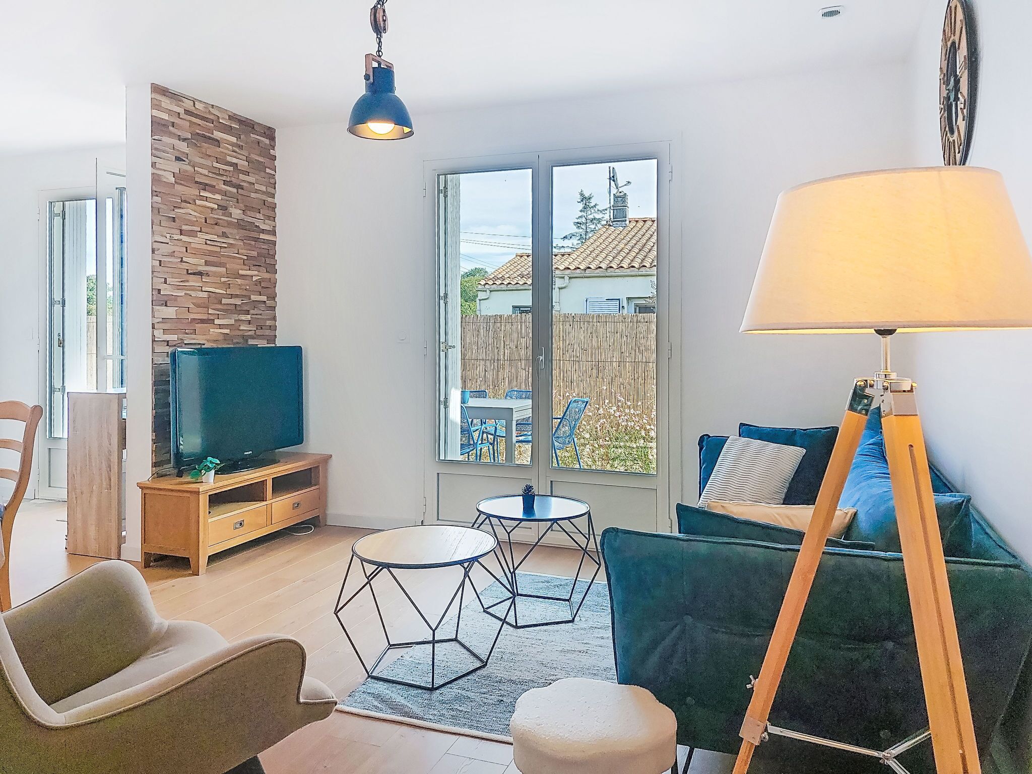 A modern living room with a TV, sofa, and lamp.