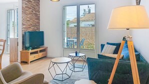 Een moderne woonkamer met een televisie, bank en lamp.