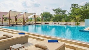 A swimming pool with lounge chairs and a sunshade structure.