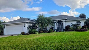 A single-story house with a garage, a front entrance with a door, and a well-maintained lawn. -   Great 4-bedroom house in Englewood with pool, on a canal, 15 min. from beach. (Englewood)
