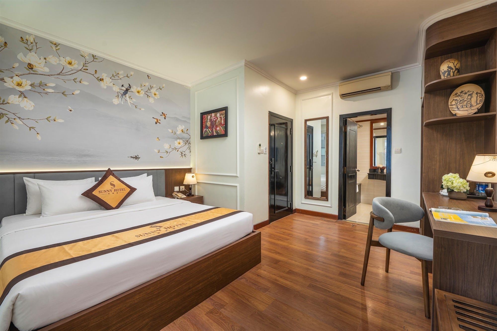 Una habitación de hotel con una cama, un escritorio, una silla, un armario y una puerta que da a un baño.