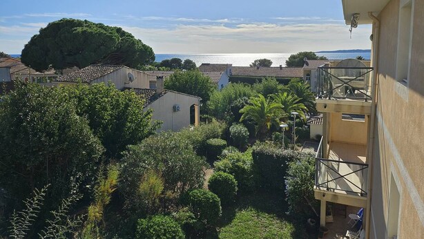 A residential area with a view of the sea, surrounded by greenery and houses with tiled roofs. - Large 2-room luxury residence for 4 people with swimming pool and air conditioning. (LES ISSAMBRES)