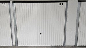 A row of closed, white metal doors with numbers 52 and 51 visible. - Large 2-room luxury residence for 4 people with swimming pool and air conditioning. (LES ISSAMBRES)