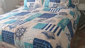 A bed with a nautical-themed quilt, white headboard, and matching pillows. - Welcoming Bed & Breakfast with Air Conditioning in the Heart of Windhoek (Windhoek)