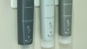 Une salle de bain équipée de trois distributeurs pour le gel douche, le shampooing et l’après-shampooing.