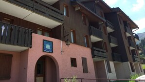 A multi-story building with balconies and a sign that reads "LES PIERRES PLATE".