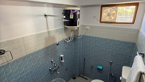 A small bathroom with a toilet, sink, and shower. - Story Homes- Deluxe Room (Kaza Khas)