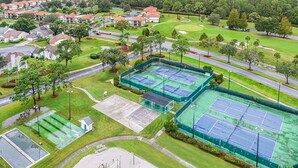 An aerial view of a residential area with multiple tennis courts, a playground, and a golf course. - Upstay 2BR Golfer s Retreat w Patio Ventura Resort (Orlando)