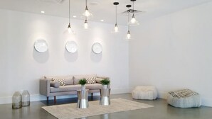 Un salon moderne avec un canapé gris, des décorations murales rondes et une table basse agrémentée de deux plantes en pot.