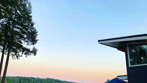 A lakeside view with a house, a dock, and a clear sky.