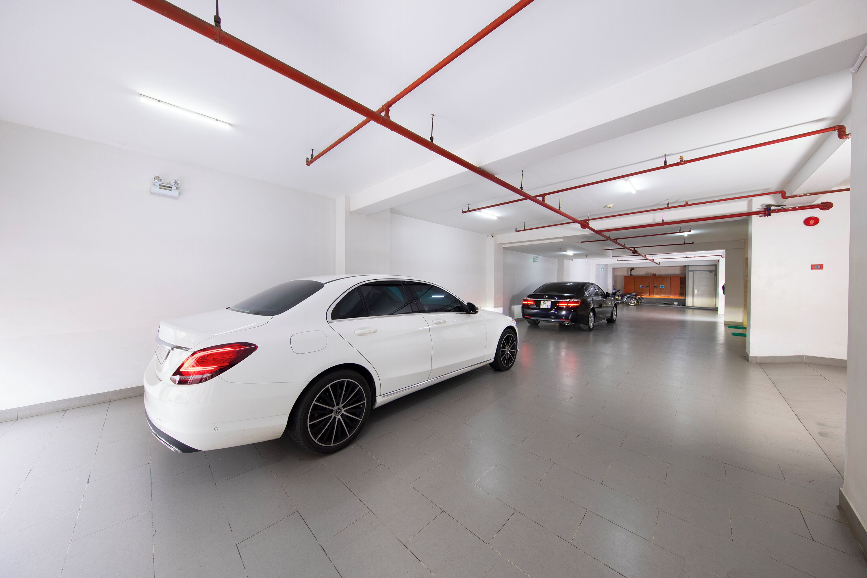 A modern, clean parking garage with white walls and a polished floor.