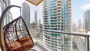 Un immeuble de grande hauteur au design moderne, doté de nombreux balcons et d’une façade en verre.