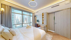 Une chambre d’hôtel moderne, dotée d’un grand lit, d’un bureau et d’une armoire.