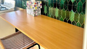 Una cocina con encimera de madera, dos sillas de mimbre y una caja decorativa para pañuelos.