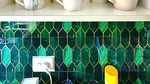 Una repisa de cocina con tazas blancas apiladas y algunos tazas blancas con diseños de mármol.