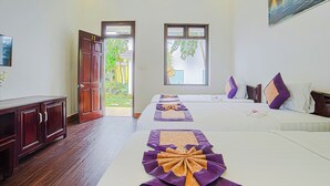 Quarto de hotel com duas camas, um armário de madeira e vista para o verde lá fora.
