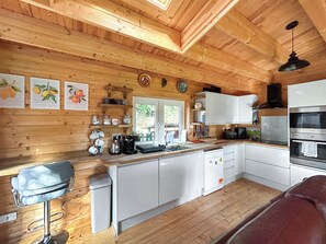 Een houten cabinemiddenstuk met een keuken, eethoek en een raam.
