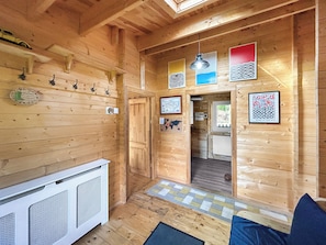 A wooden interior with a kitchenette, a door leading to another room, and artwork on the walls. - 2 bedroom accommodation in Sevenoaks (Sevenoaks)