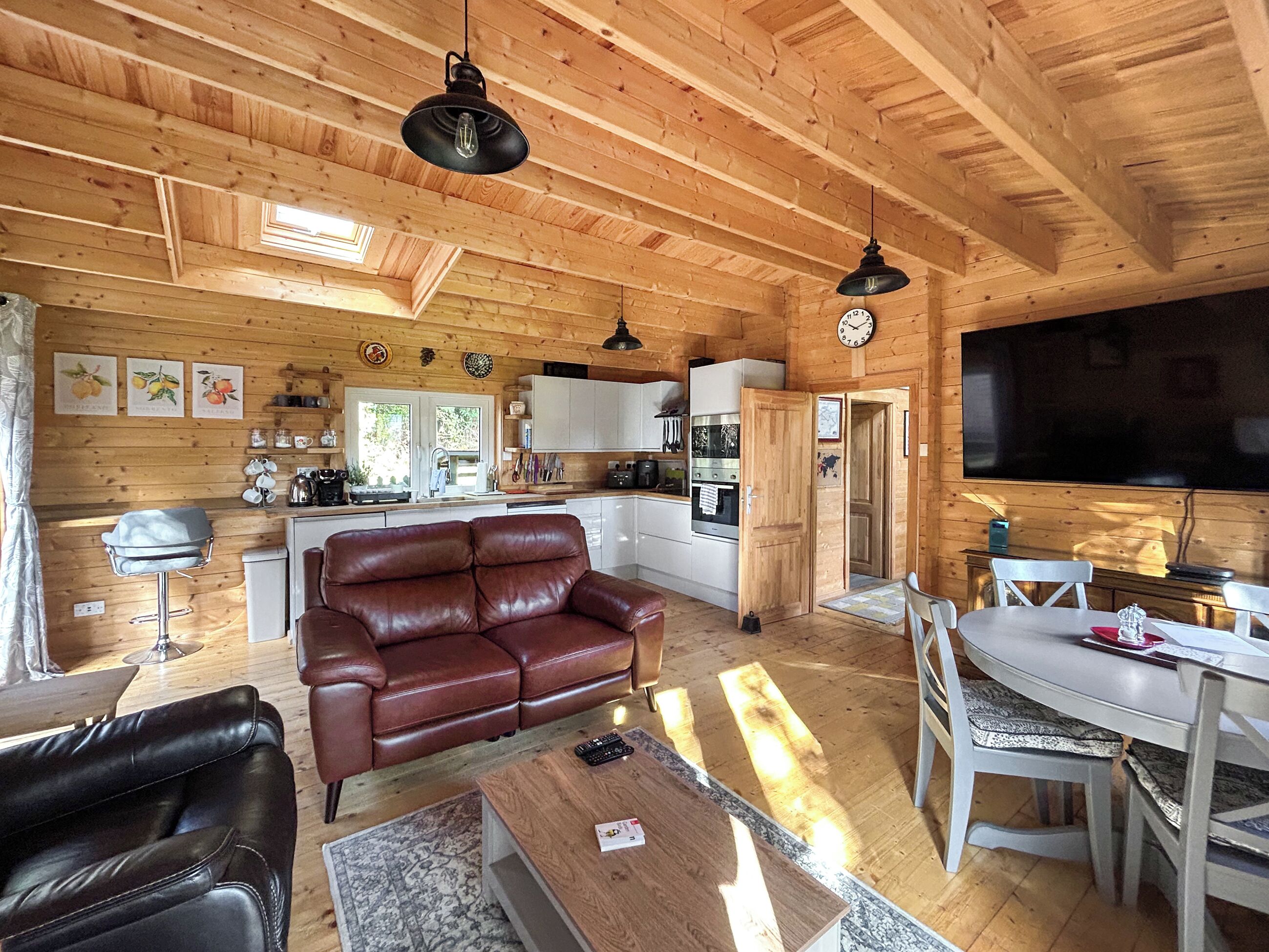 Un intérieur en bois comprenant un canapé, une table basse et une table à manger.