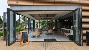 An outdoor cafe area with wooden furniture and a chalkboard menu. - OCEAN BREEZE VILLA CAM RANH (Cam Lam)