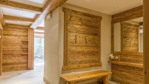 A wooden interior with a bench, a wooden wall panel, and a mirror. - Apartment with a spa next to the gondola (Brixen im Thale)