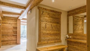 A wooden interior with a bench, a wooden wall panel, and a mirror. - Holiday Apartment with a spa next to the gondola (Brixen im Thale)