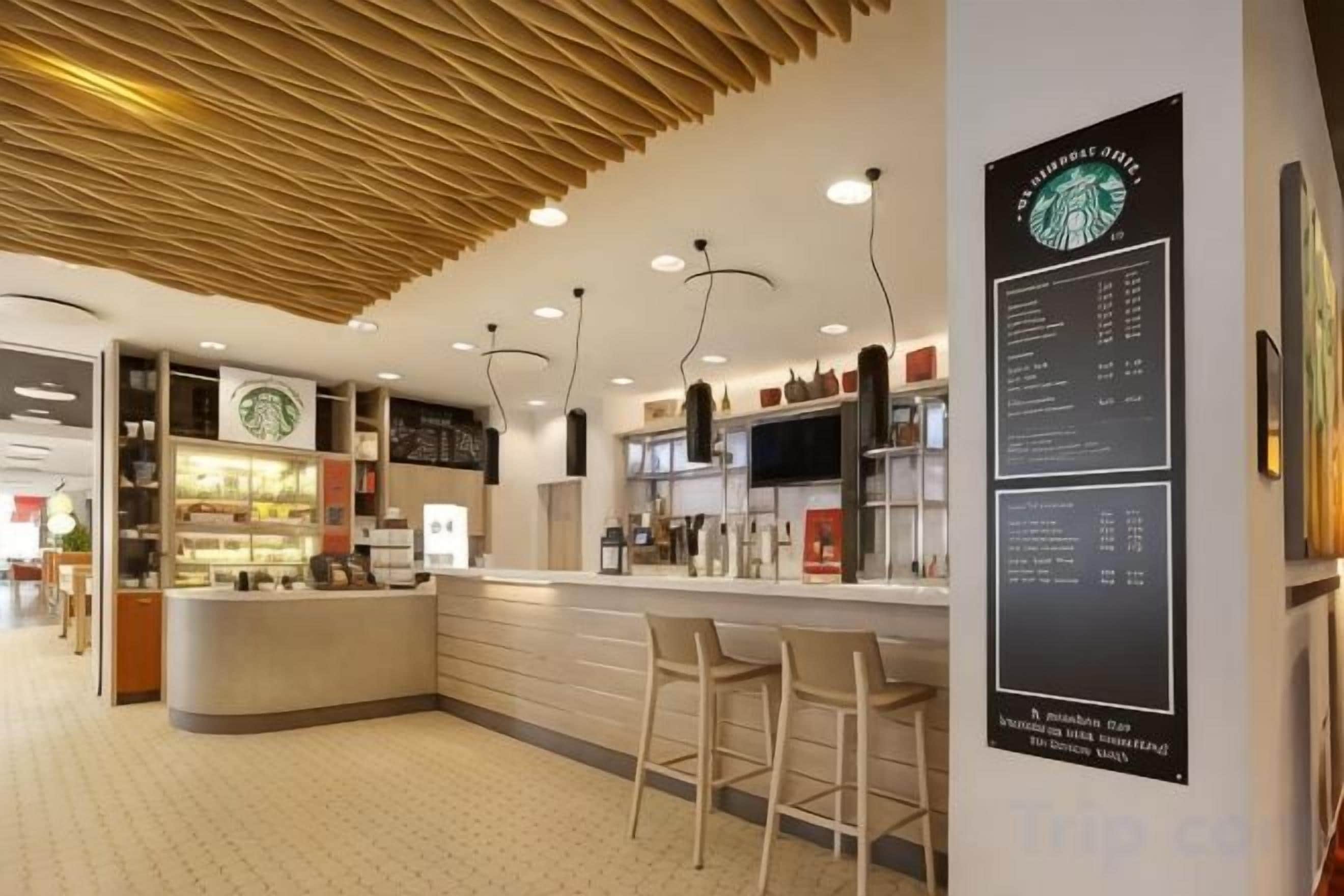 A modern interior with a bar area, seating, and a menu board.