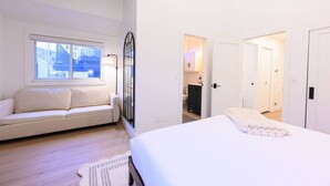 A bedroom with a bed, a sofa, a window, and a door leading to a bathroom. - Labor Day Sale - Limited Time Offer, Save up to 30% (Park City)