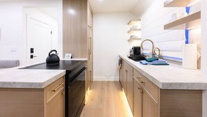 A modern kitchen with wooden cabinets, a black stove, and a sink with gold fixtures. - Labor Day Sale - Limited Time Offer, Save up to 30% (Park City)