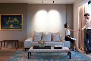 A modern living room with a sofa, coffee table, and artwork on the wall. - NJV Athens Plaza (Athens)