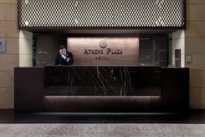 A reception desk with a marble top and a sign that reads 'ATHENS PLAZA HOTEL.' - NJV Athens Plaza (Athens)