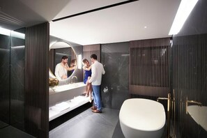 A modern bathroom with a large bathtub, a vanity with a mirror, and a shower area. - NJV Athens Plaza (Athens)