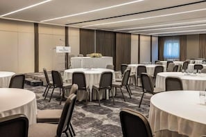 A conference room with round tables, chairs, and a podium. - NJV Athens Plaza (Athens)