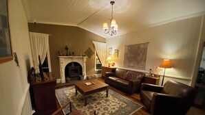 Ein gemütliches Wohnzimmer mit Kamin, Ledermöbeln und einer Kristallleuchter.