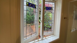 Ein Zimmer mit einer weißen Tür und einem Fenster mit Buntglas.