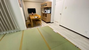 A room with tatami mats, a wooden table, a TV, and a microwave. - Core Royal-Vacation Rental (Kyoto)