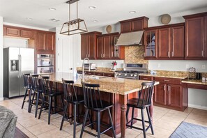 A modern kitchen with granite countertops, stainless steel appliances, and dark wooden cabinets.
