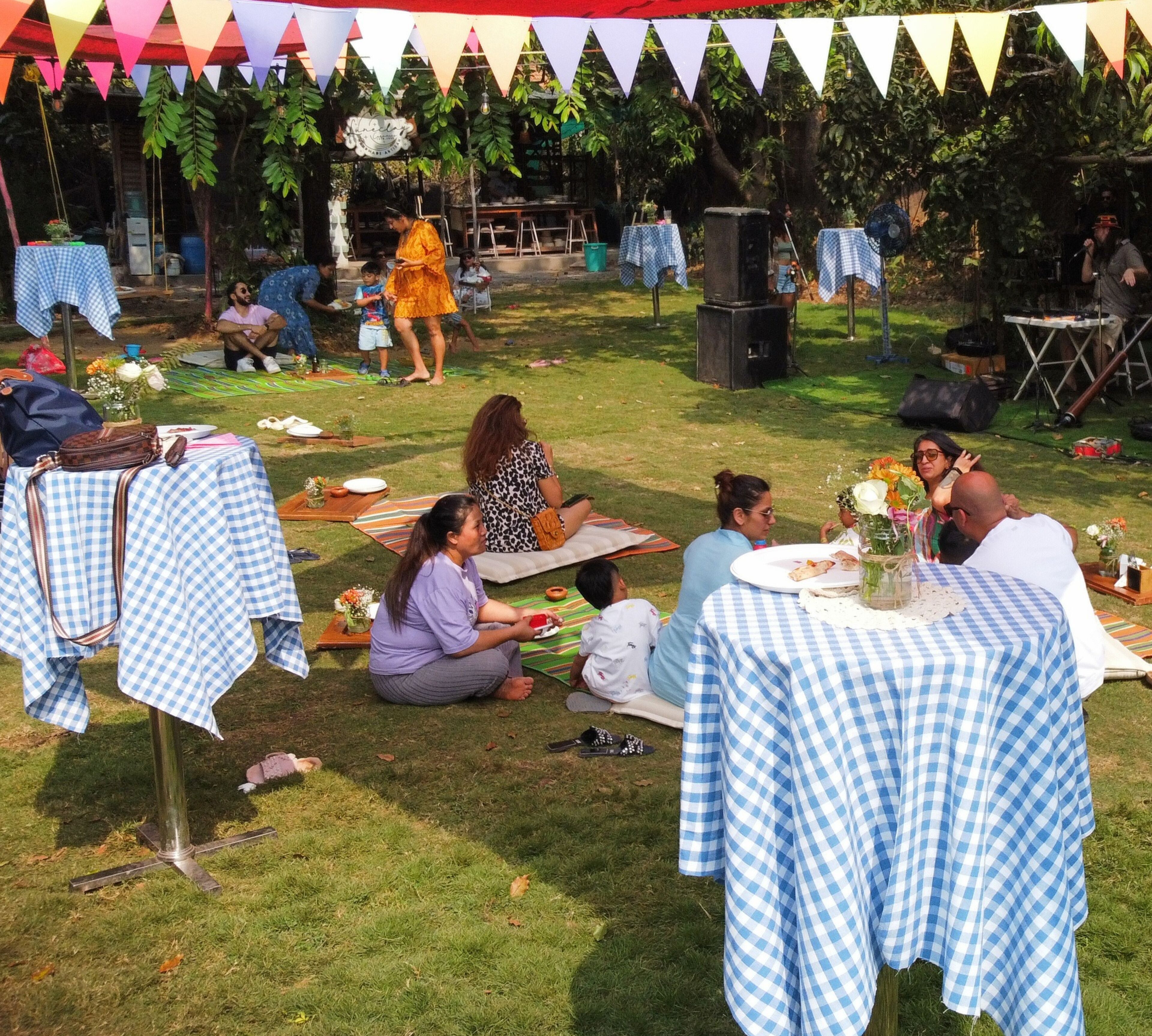 An outdoor dining area with checkered tablecloths, tables, and chairs.