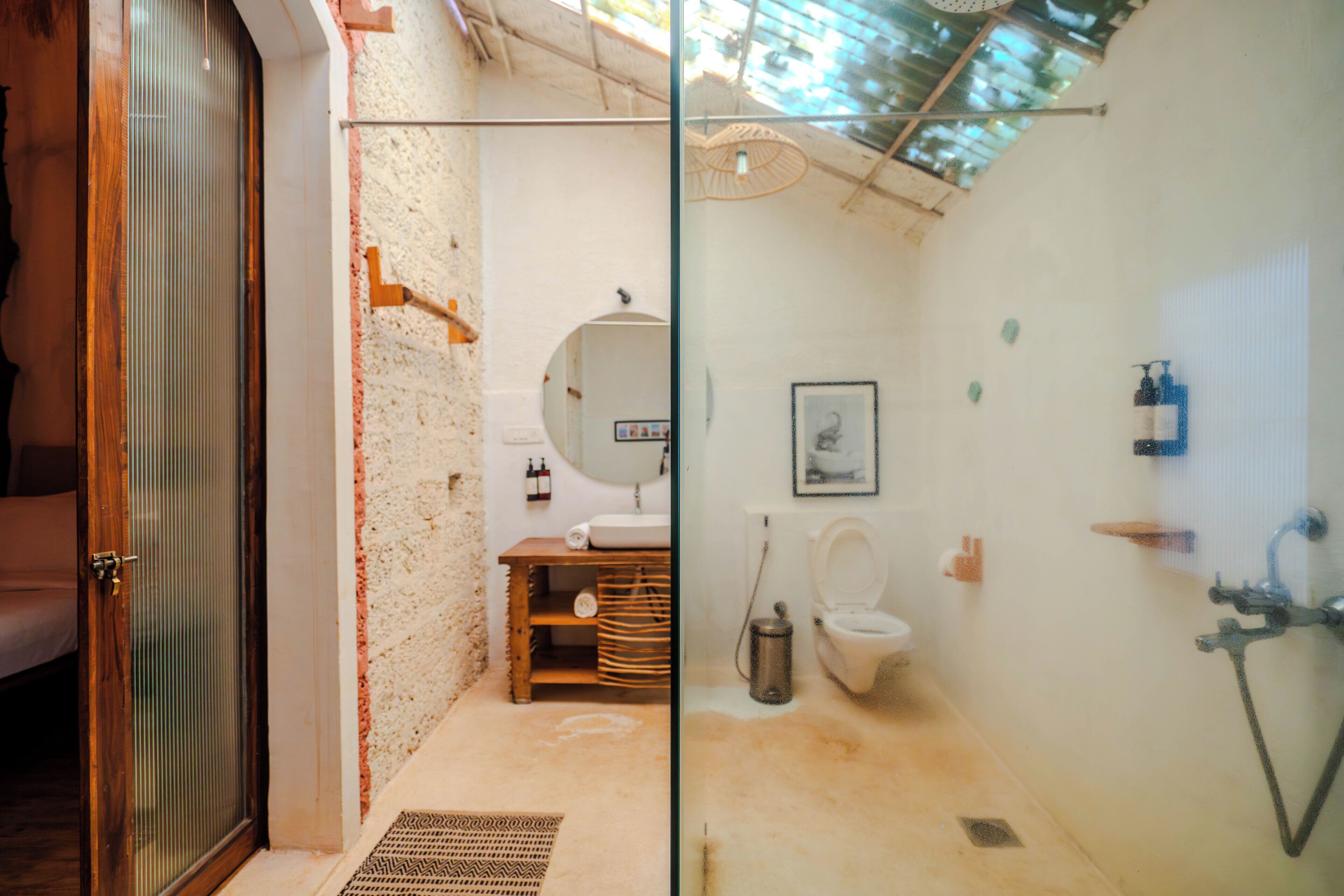 A compact bathroom with a wooden vanity, a toilet, and a shower.