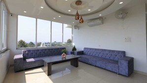 A modern living room with a sectional sofa, a coffee table, and pendant lighting. - Evana Rajaji  (Ganga Bhogpur Malla)