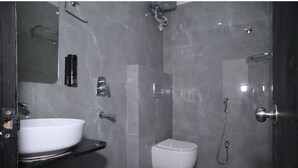 A modern bathroom with a white sink, a toilet, and a shower. - Hotel Nirvvana Residency (Varanasi)