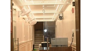 A reception area with a wooden desk, a Lenovo computer, and a sign labeled "RECEPTION". - Hotel Nirvvana Residency (Varanasi)