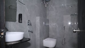 Un baño moderno con lavamanos blanco, inodoro y ducha.