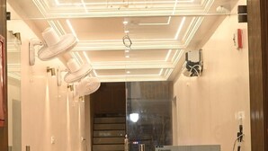 Un área de recepción con un escritorio de madera, una computadora Lenovo y un letrero que dice "RECEPTION".