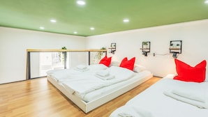 Een moderne hotelkamer met twee bedden, een groot raam en een groen plafond.