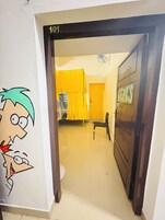 Un pasillo con una puerta marcada con el número 101 y una pared decorada con personajes de dibujos animados.