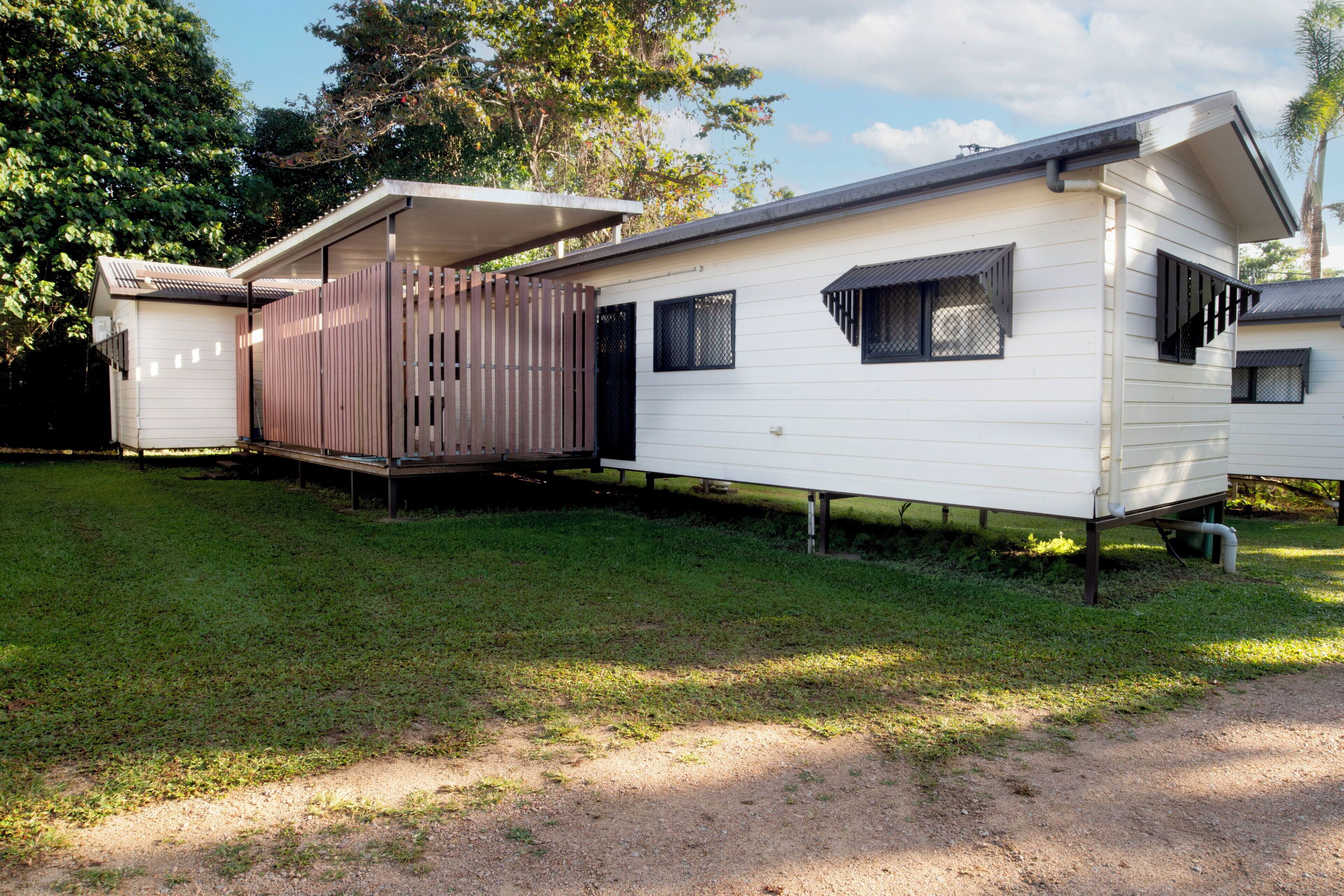Una casa móvil con un porche cubierto y un área exterior cercada.